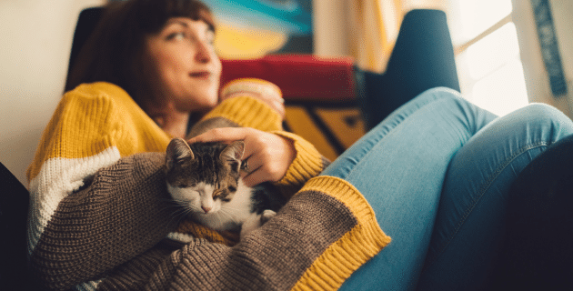 Woman sitting at home with kitten on her lap