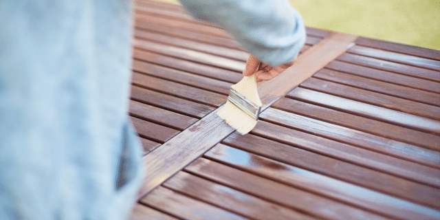 an image of a person staining a deck